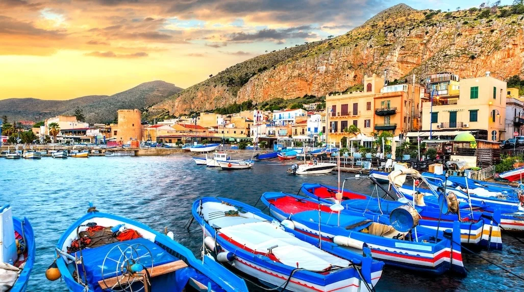 Le port et le village de Mondello en Sicile à Coté de Palerme. Ce village de pêcheurs aux eaux turquoises avec ses bateaux colorés et ses bâtisses de front de mer, le tout sous le soleil de Sicile Ce village réputé pour sa côte magnifique, l’une des plus belles que l’on trouve en Sicile.